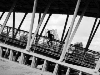 Young boy running on the bridge near the Louvre museum