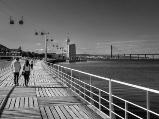 Couple walk near the Vasco de Gama bridge in Lisbon
