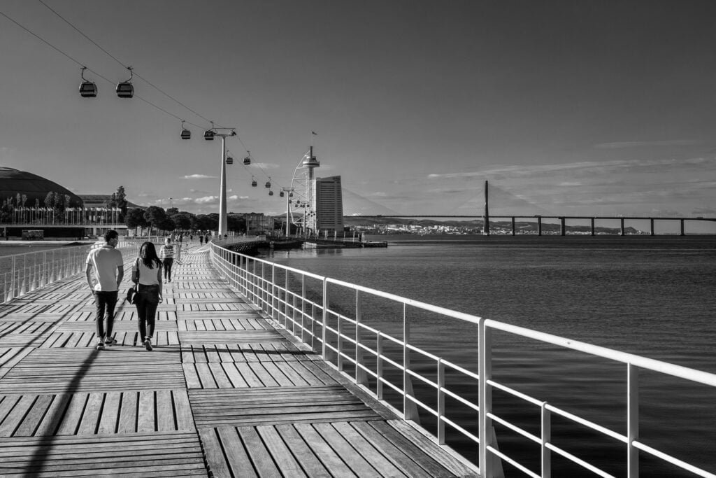 Couple walk near the Vasco de Gama bridge in Lisbon