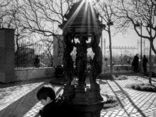 Young boy playing at the fountain in Belleville, Paris