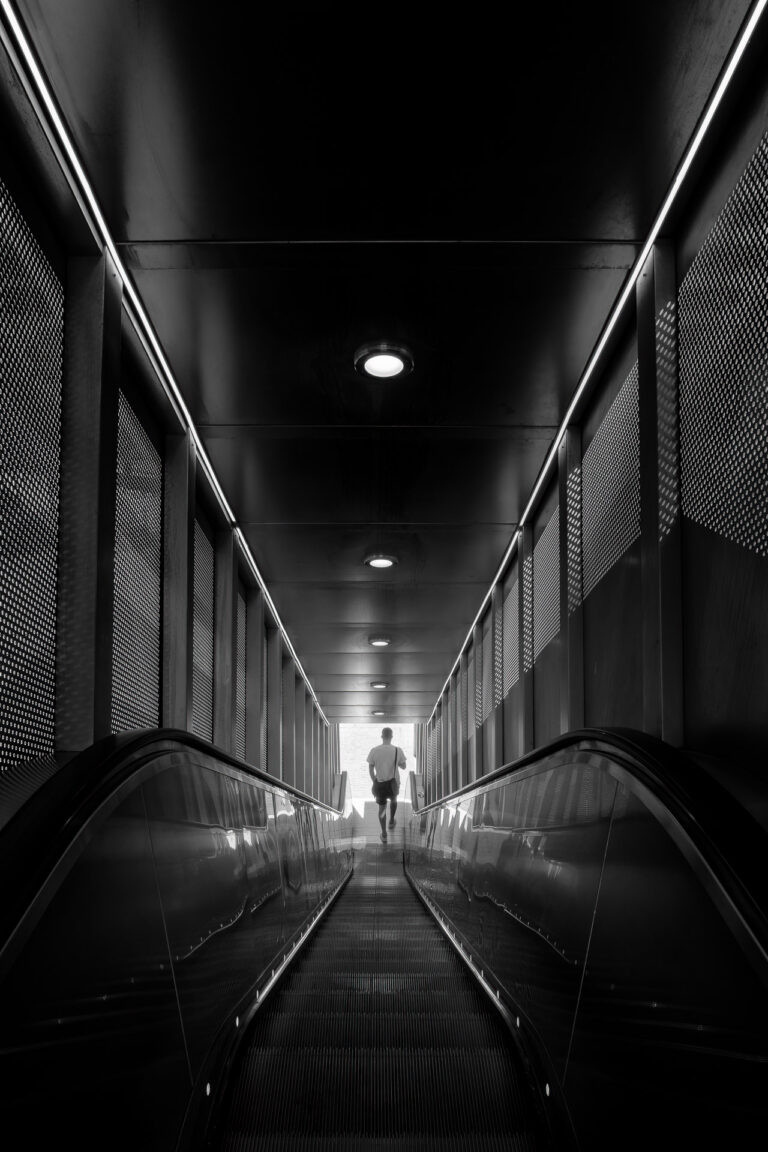 Mann auf der Rolltreppe in La Défense, Paris.