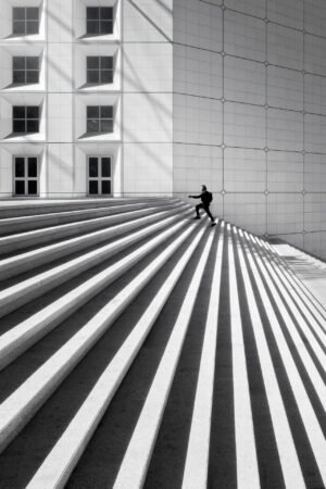 Man climbing the step at La Defense arch, Paris