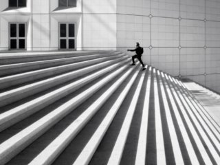 Man climbing the step at La Defense arch, Paris