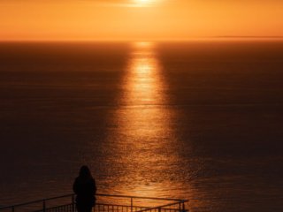 Woman watching the sunset at Blanc-Nez cap, France