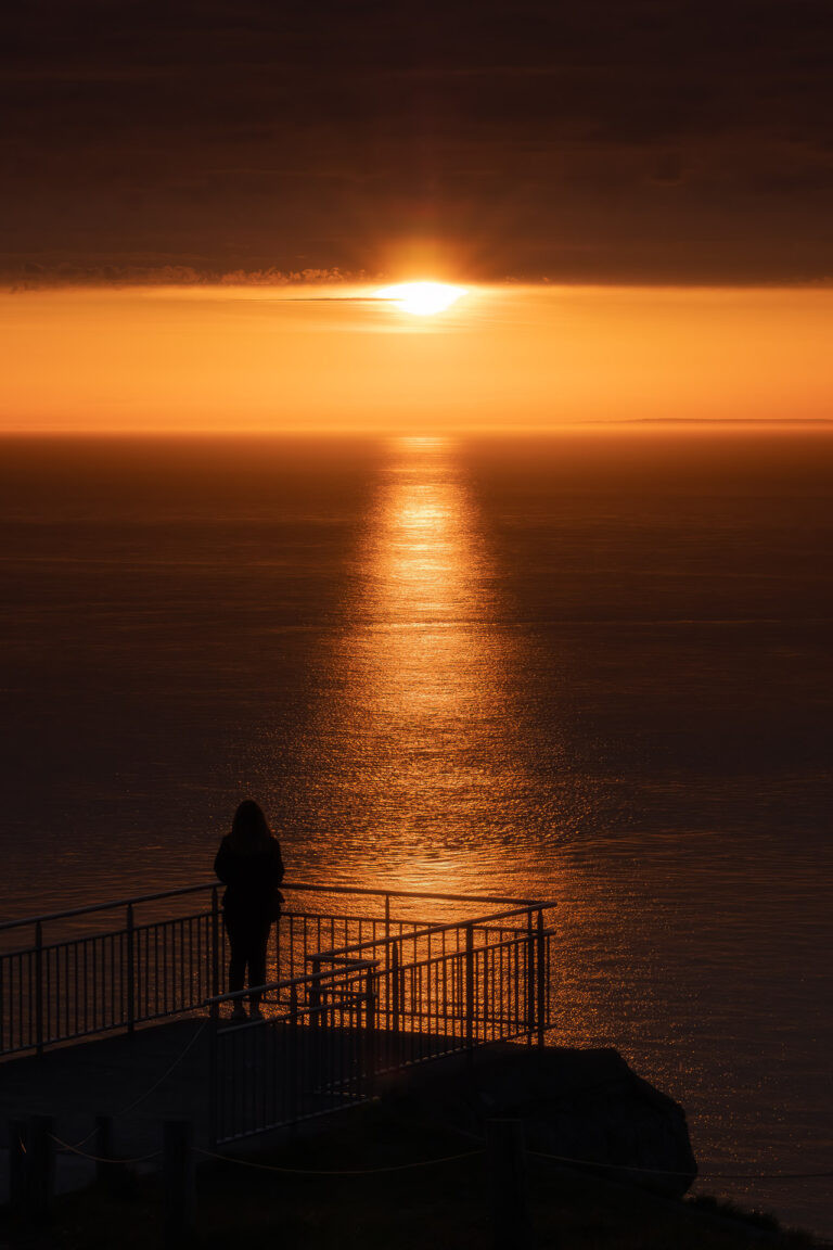 Woman watching the sunset at Cap Blanc-Nez, France.