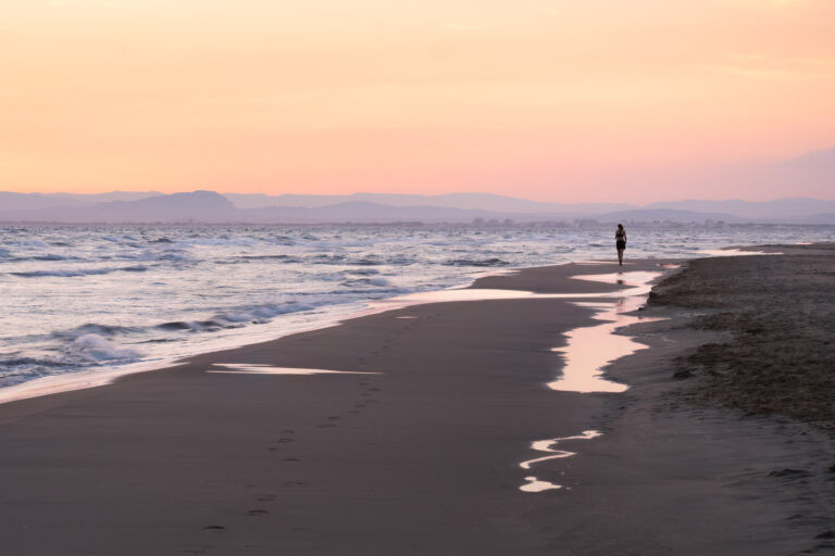 Women walking on the Espiguette beach at Le Grau-du-Roi, France.